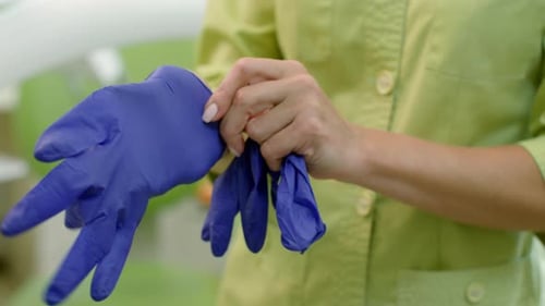 Female doctor hands putting on sterile surgeon gloves in hospital lab