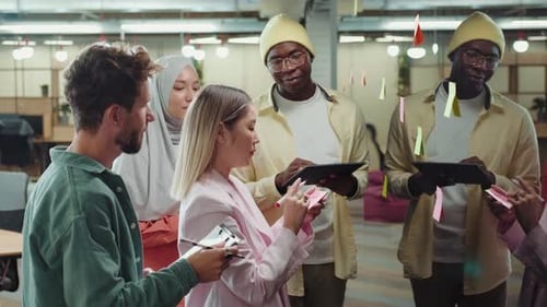 Creative Multiethnic Business Team Making Notes on Sticky Notes Near the Blackboard