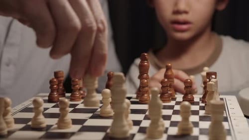 Vater fängt Ritter im Schachspiel ein, als das Kind reagiert