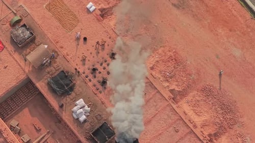 Drone view of smoking brick factory with workers in Bangladesh