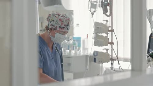 Female Doctor in Medical Mask and Butterfly Print Cap Using Stethoscope Healthcare Professional