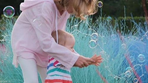 Baby Girl with Older Sister Catching Soap Bubbles