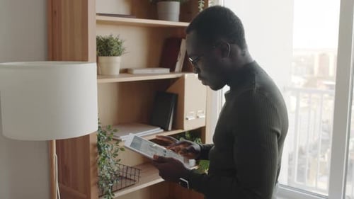 Man Using Tablet Indoors By Window
