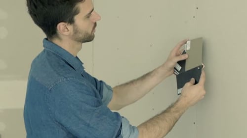 Man Choosing Wall Paint Colors in New Home