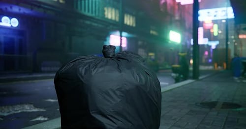 Bolsa de basura en una calle de la ciudad en un entorno urbano iluminado con neón por la noche