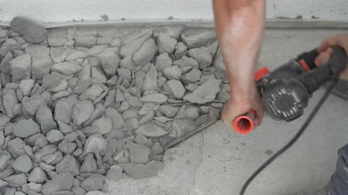 Construction Worker Breaks Up Concrete With Jackhammer