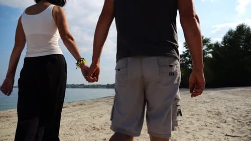 Couple Holding Hands of Each Other and Walking at Coast Happy Pair Going Along Seashore at Sunny Day