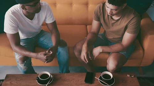 Friends, talking and above of men in coffee shop for bonding, discussion and chat together