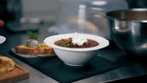 in a Professional Kitchen White Deep Plate with Borscht and Bowl with Soup Restaurant Serving