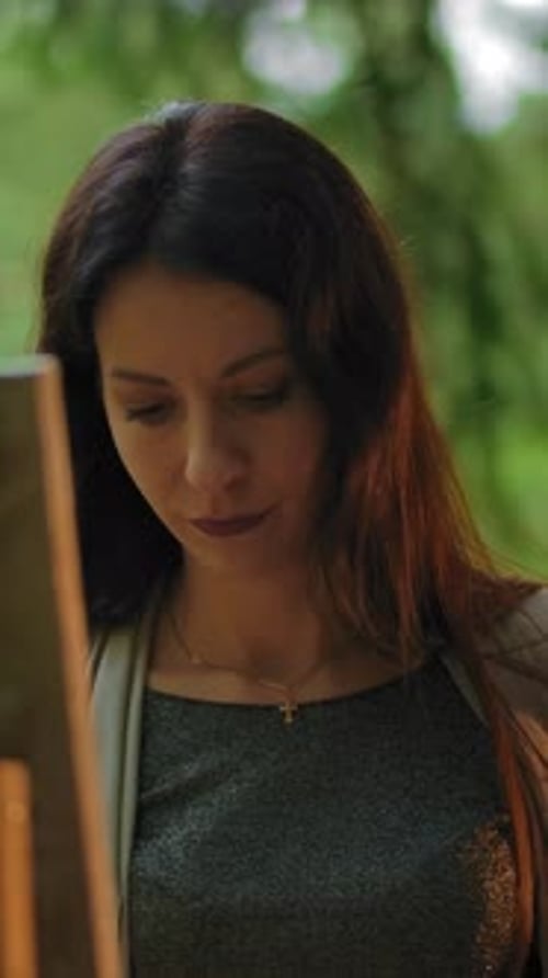 Vertical of Portrait of Young Woman Painting a Landscape at an Easel