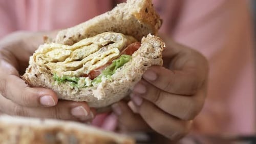 Close Up of Delicious Egg Sandwich Being Held