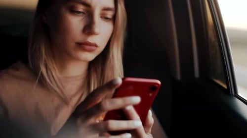Woman Using Smartphone While Riding in Car