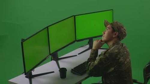 Side View Of Man Soldier Thinking While Working With Mock Up Multiple Monitor In Green Screen