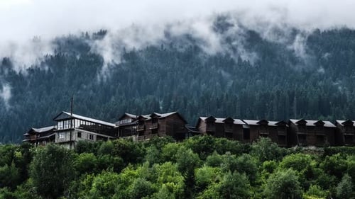 Misty Morning Fog Over Wooden Cottages in the Mountains