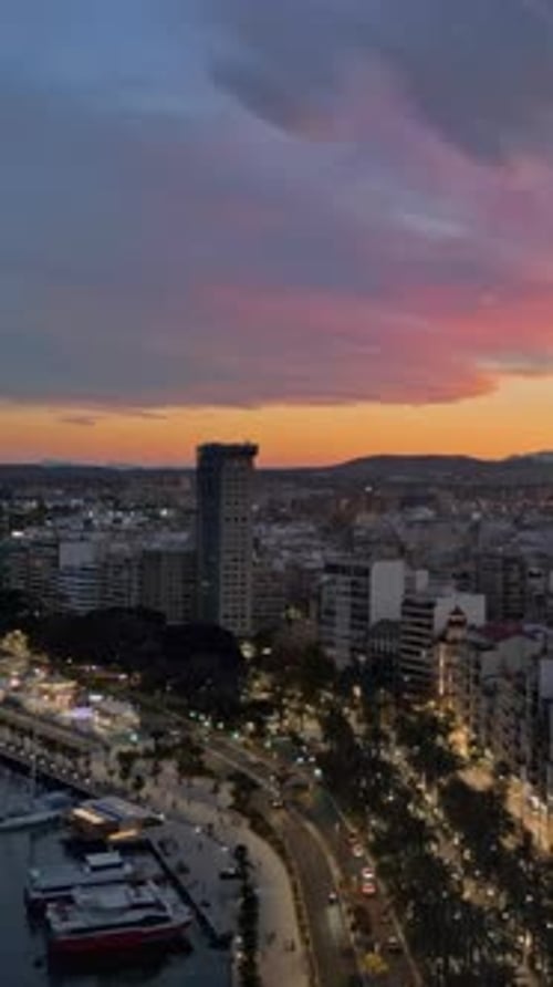 Aerial drone view of the sea and the Alicante city in Spain at sunset. Vertical
