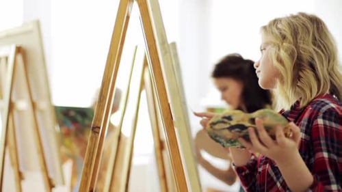 Art School, Creativity And People Concept - Group Of Students With Easels And Palette Knifes Pain...