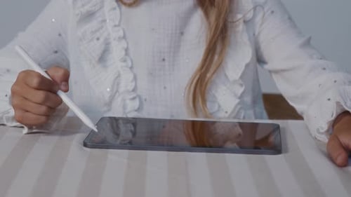 Young Child Drawing on Tablet with Stylus Indoors