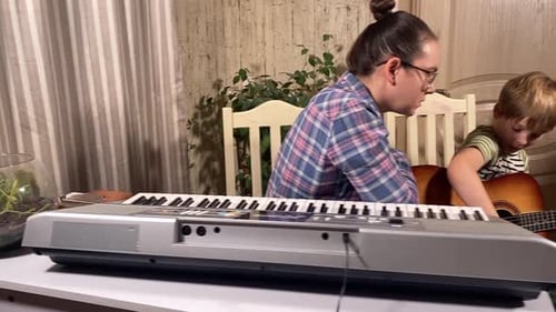 Woman and Child Play Music Together Inside Home