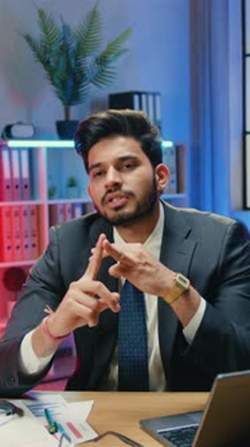 Handsome Man Office Manager in Formal Wear Sitting in Front of Video Camera in Workroom with Night