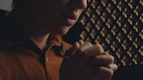 Young Woman Saying Contrition Prayer during Confession in Church