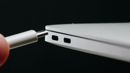 Ladeanschluss zum Laptop auf schwarzem Hintergrund, Nahaufnahme, Telefon, Ladeanschluss, USB-Kabel für Geräte