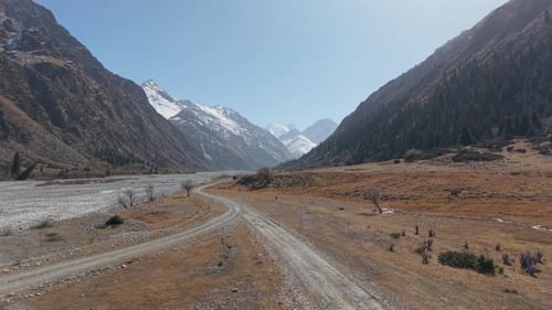 Scenic Mountain Valley View with Winding Road and Majestic Peaks Ahead