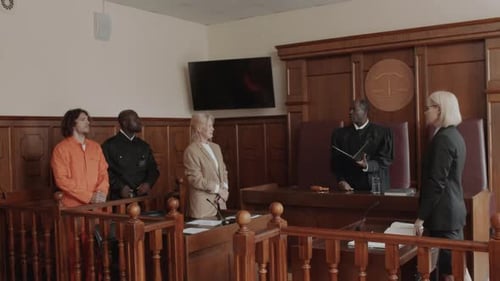 Male Judge Standing and Speaking to Female Attorney at Court Hearing