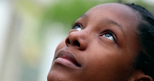 Close-Up of a Smiling Teen Girl Looking Up Outdoors