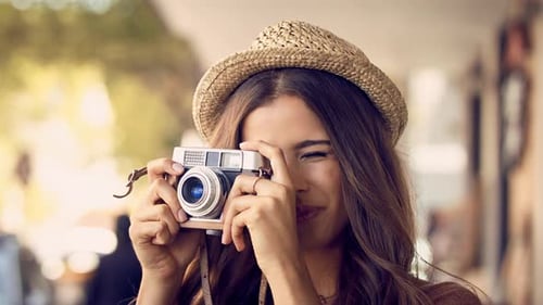 4K video footage of a beautiful young woman taking photographs on a camera in the city