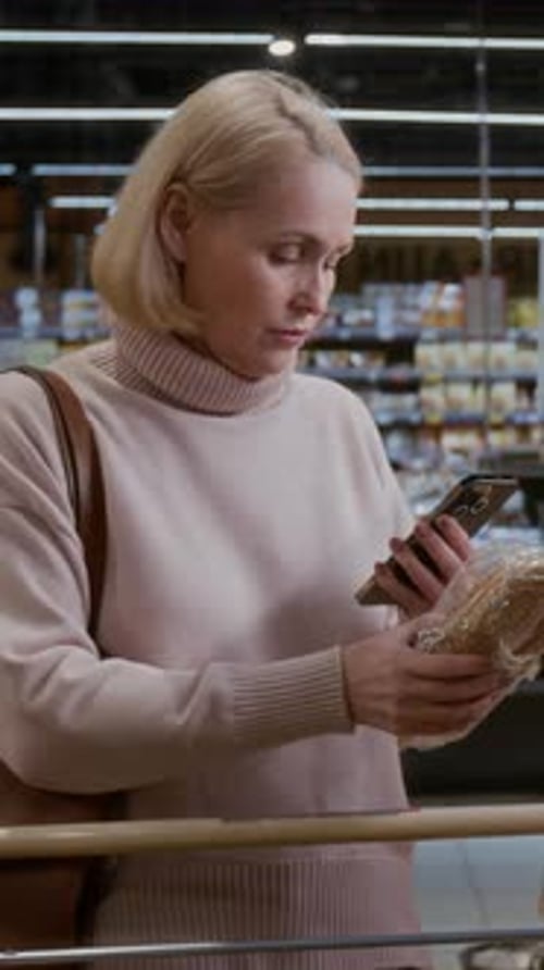 Adult Woman Choosing Fresh Bread in Grocery Store