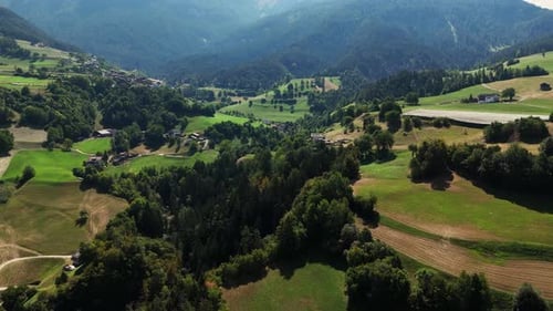 Camera panning over beautiful green valley with houses