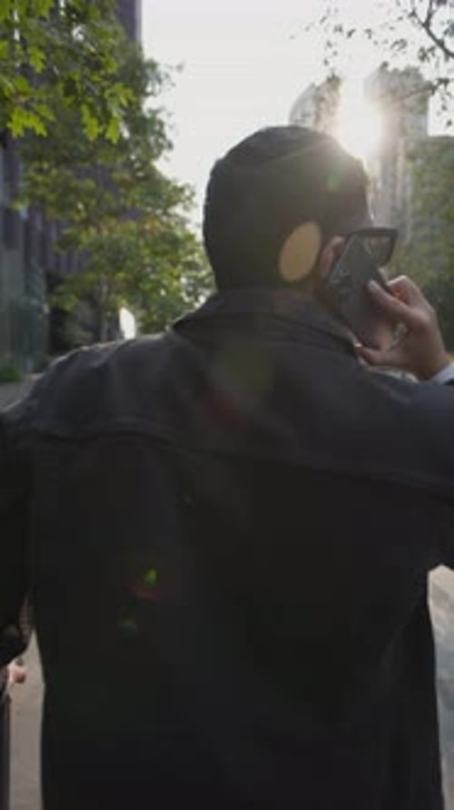 Man Walking and Talking on Phone in City