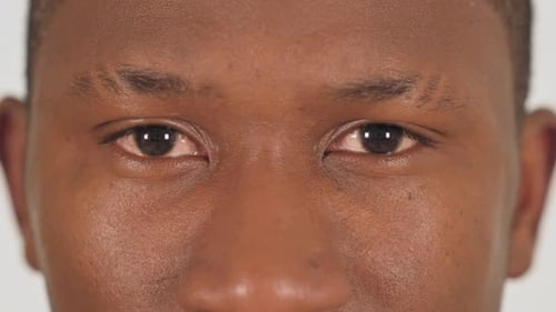 Close up of African Male Blinking Eyes on White Background