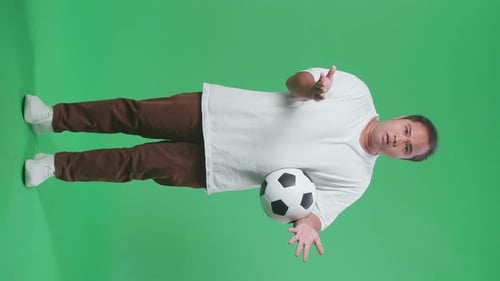 Full Body Of Asian Man With A Ball Making Fun Of The Losers While Cheering Soccer On Green Screen