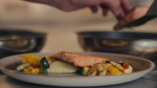 Chef serving delicious salmon with vegetables, close up