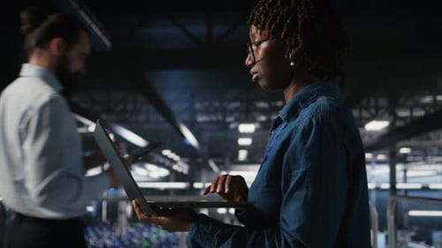 Data Center Computer Scientist Doing Maintenance Tasks on Laptop
