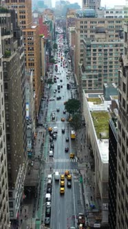 Vertical drone shot of traffic on a street in cloudy Midtown, New York, USA