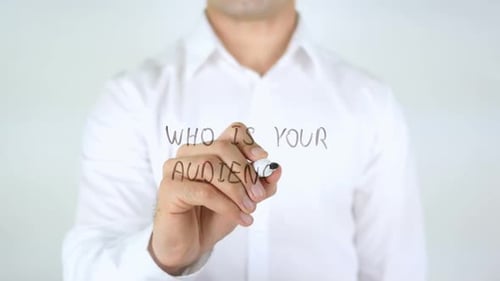 Man Writes 'Who is your audience?' on glass