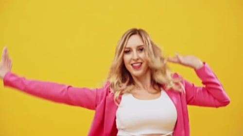 Woman Dancing in Pink Blazer on Yellow Background