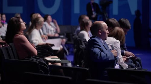 Audience members listening intently at a conference