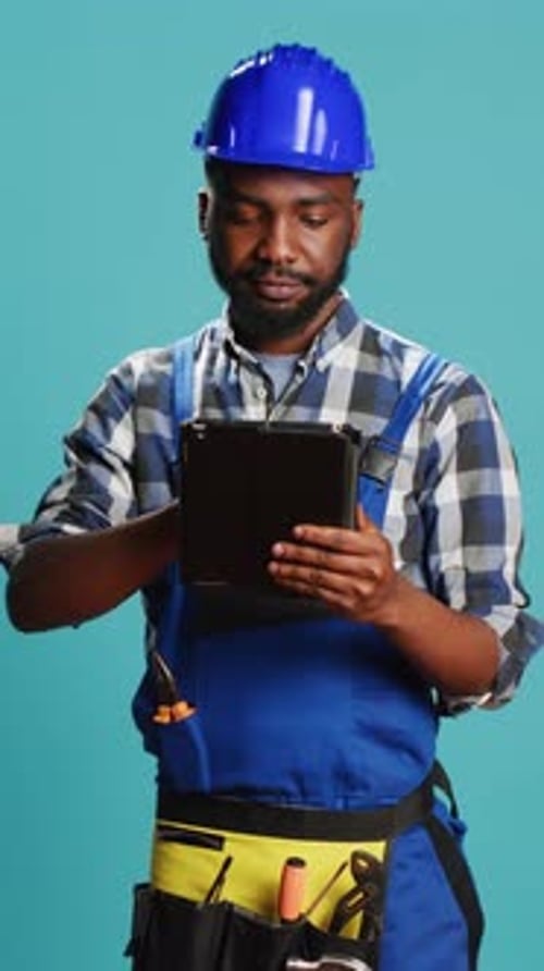 Vertical Video Young Handyman Using Digital Tablet on Camera