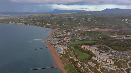 Aerial view of golf course and hotel by beach, Greece.