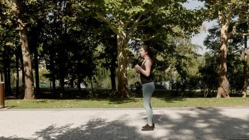 White Woman Takes a Water Break After Fitness Training in the Park on a Sunny Day