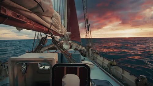 Sailing Expedition Boat Moves in the Open Sea During Bright Pink Sunrise