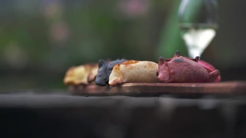 Image au ralenti d'un plateau d'empanadas avec un verre de vin Torrontés en arrière-plan.