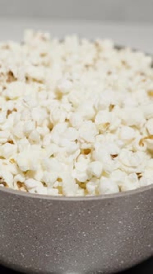 Vidéo verticale. Le pop-corn explose au fond de la casserole et fait exploser les grains déjà éclatés