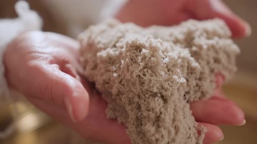 Hands Lifting Soft Soil Mold During Sensory Therapy Session Indoors