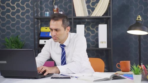 Businessman Working on Laptop in Modern Office