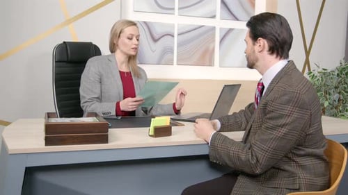 Professional Woman Discussing Documents with a Male Colleague