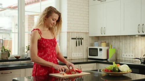 Woman in Kitchen Cutting Bell Pepper for Salad